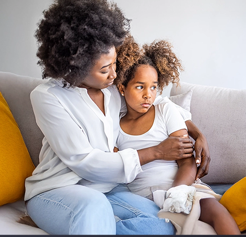 Mother and child sitting closely together in a bright living room, reflecting the emotional impact of a TNBC diagnosis in Canada.